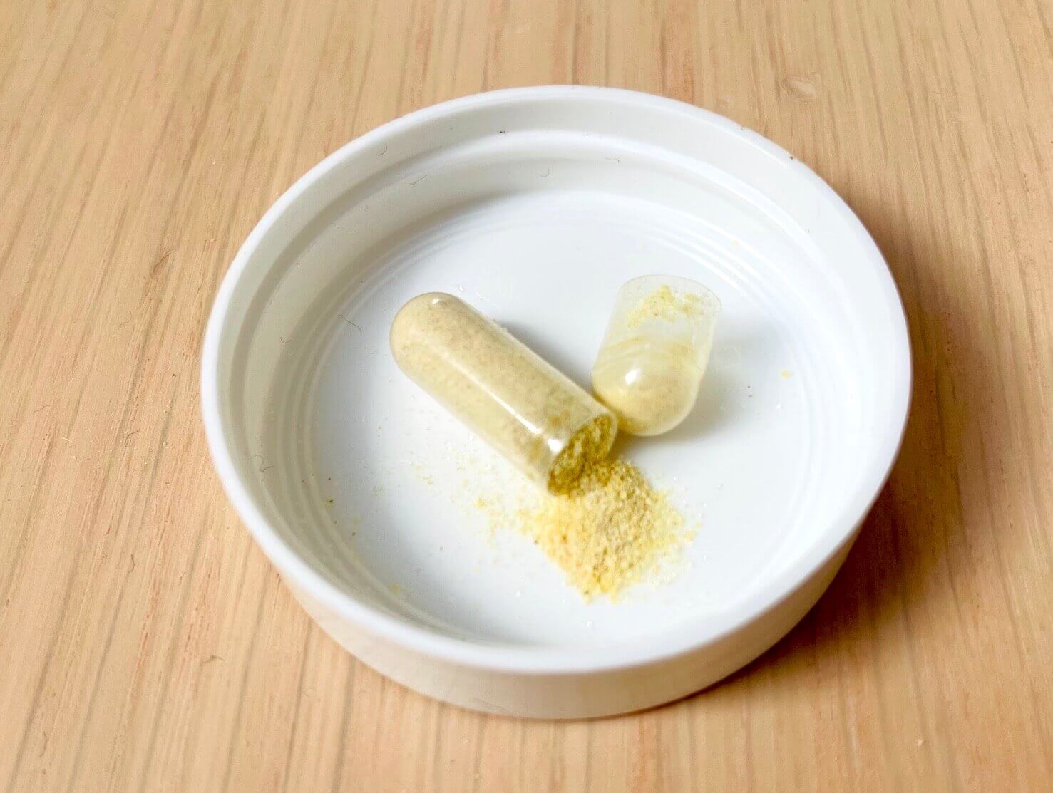 Åben kapsel med glucosamin i hætte fra emballage
