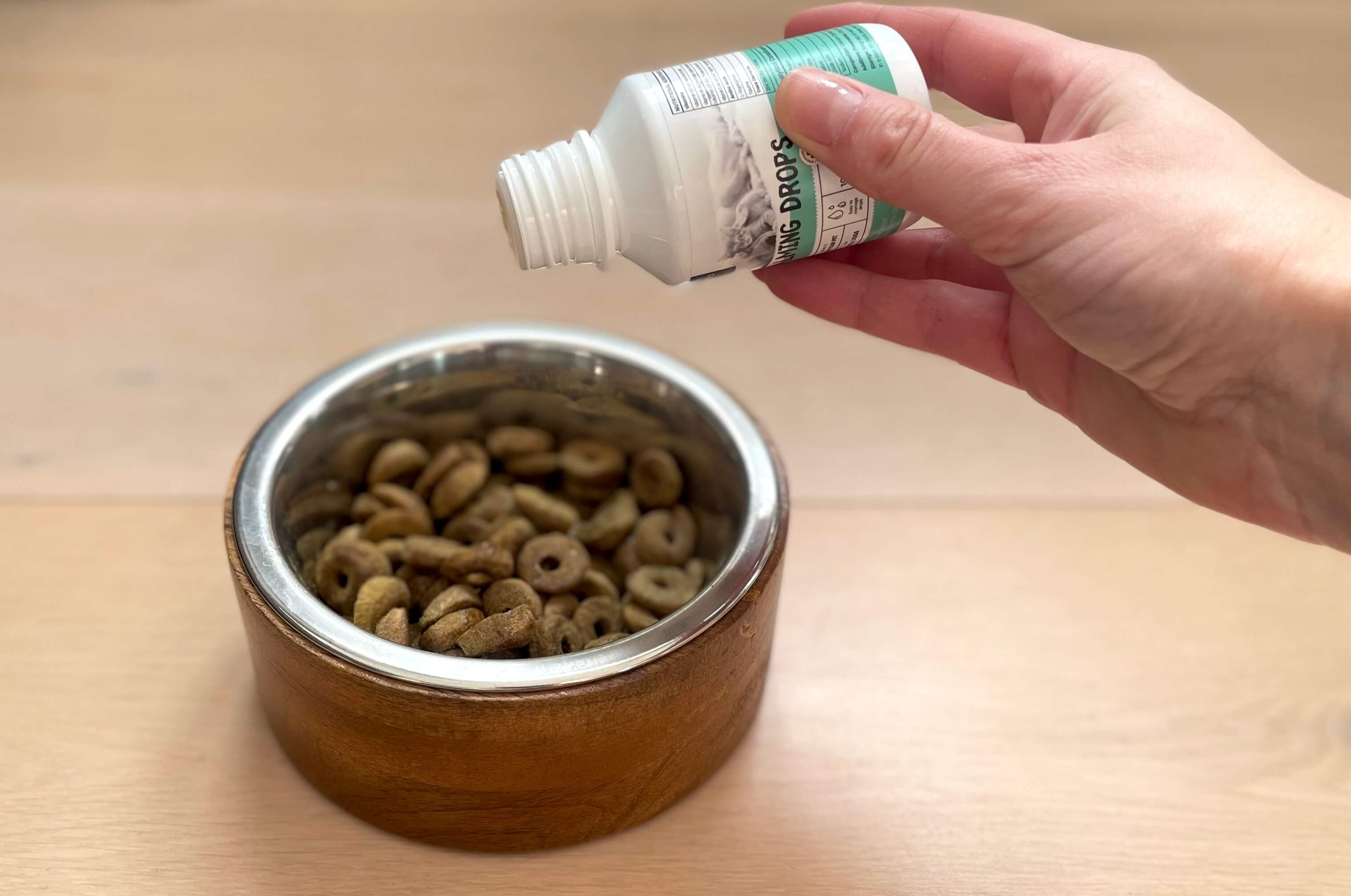 Calming drops fra Animigo hældes på hundefoder