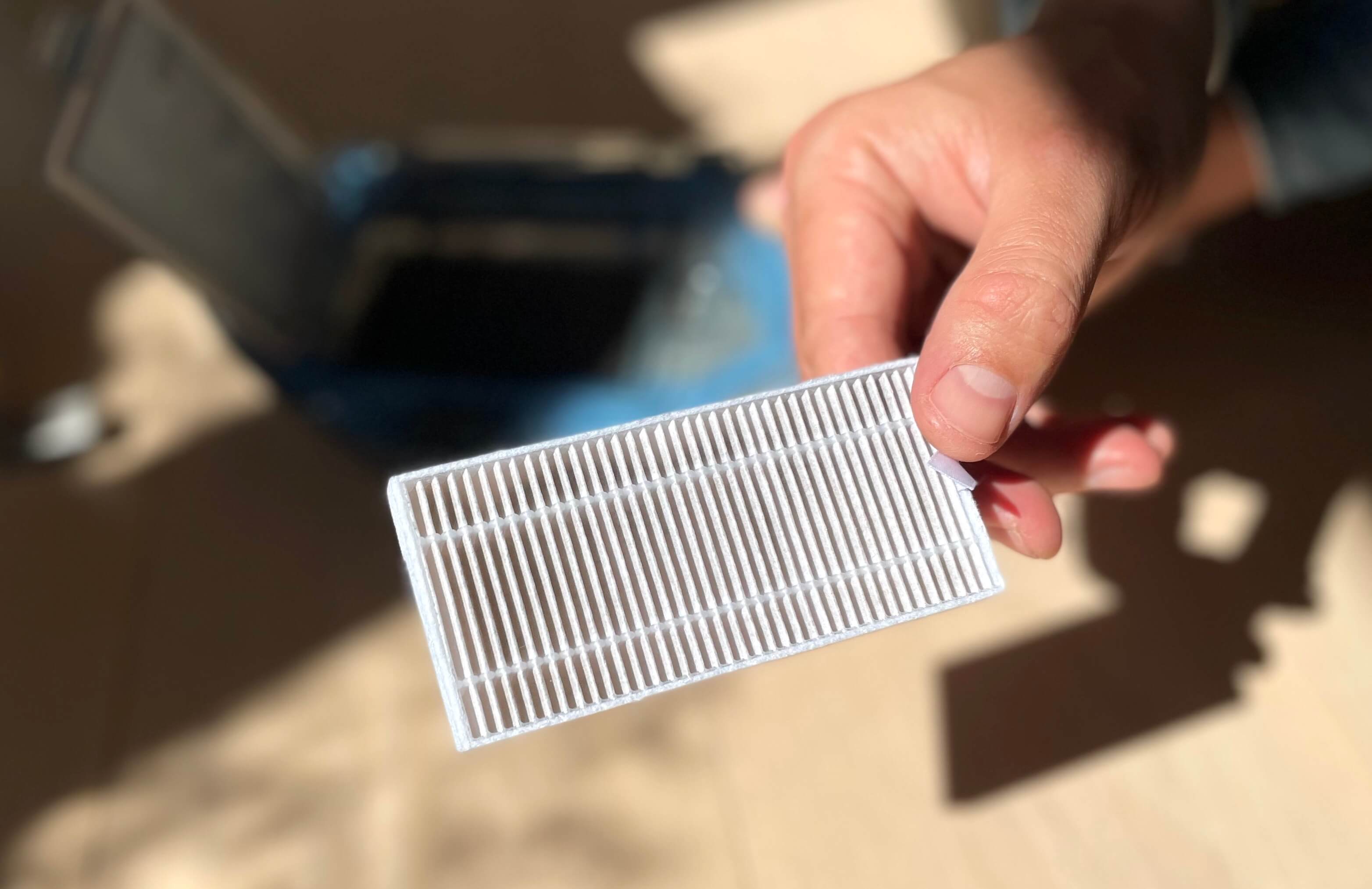 HEPA filter fra robotstøvsuger holdes i hånd af person
