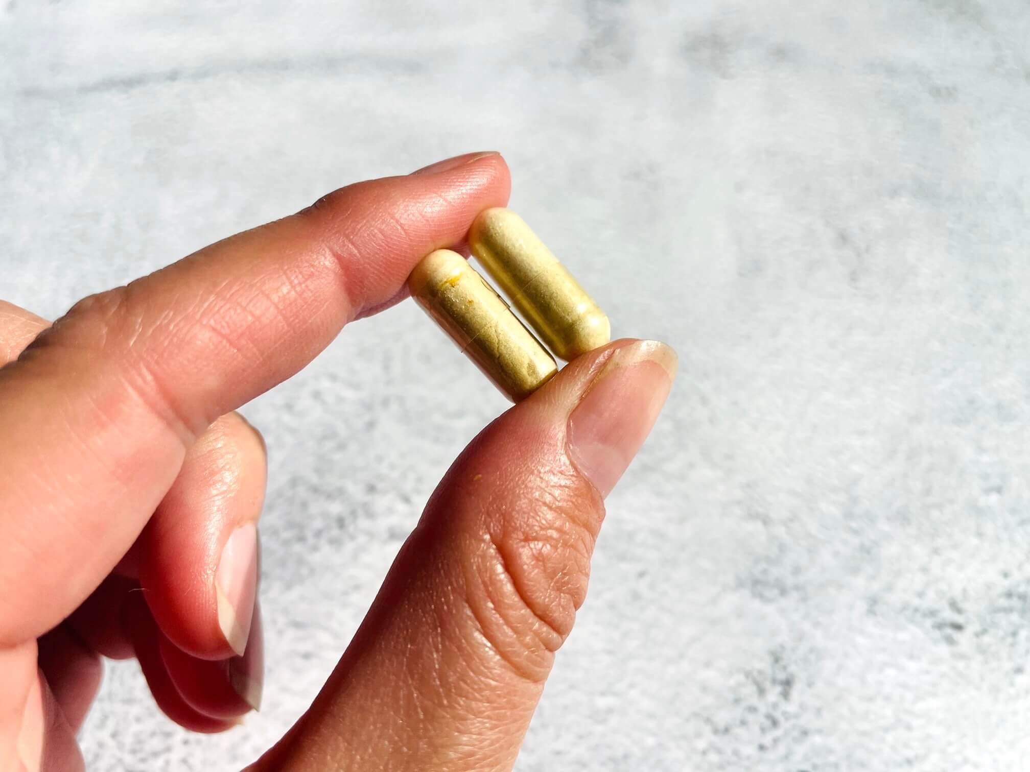Kvinde holder to glucosamin kapsler til hunde
