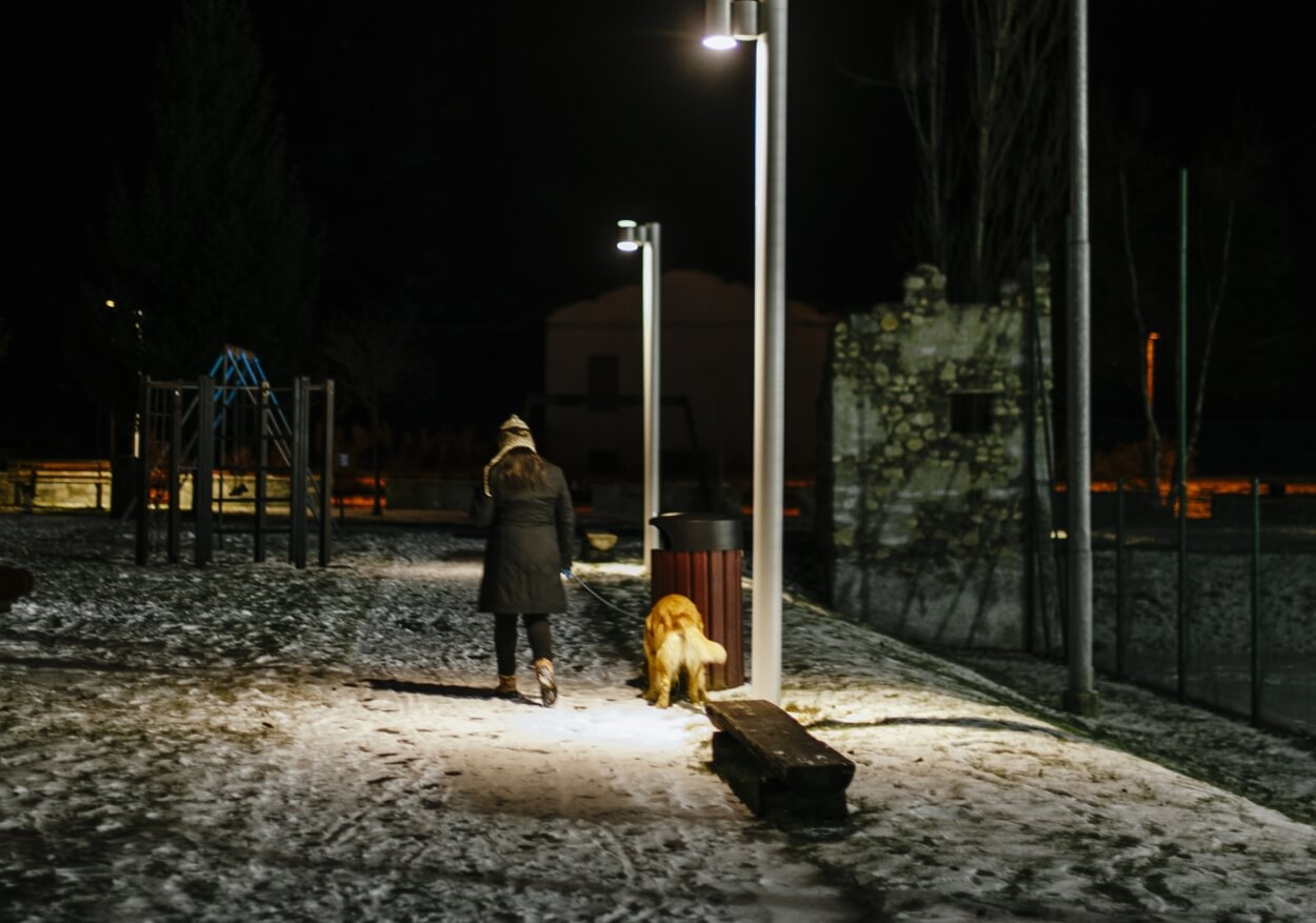 Kvinde på gåtur med hund i flexline med refleks om aftenen