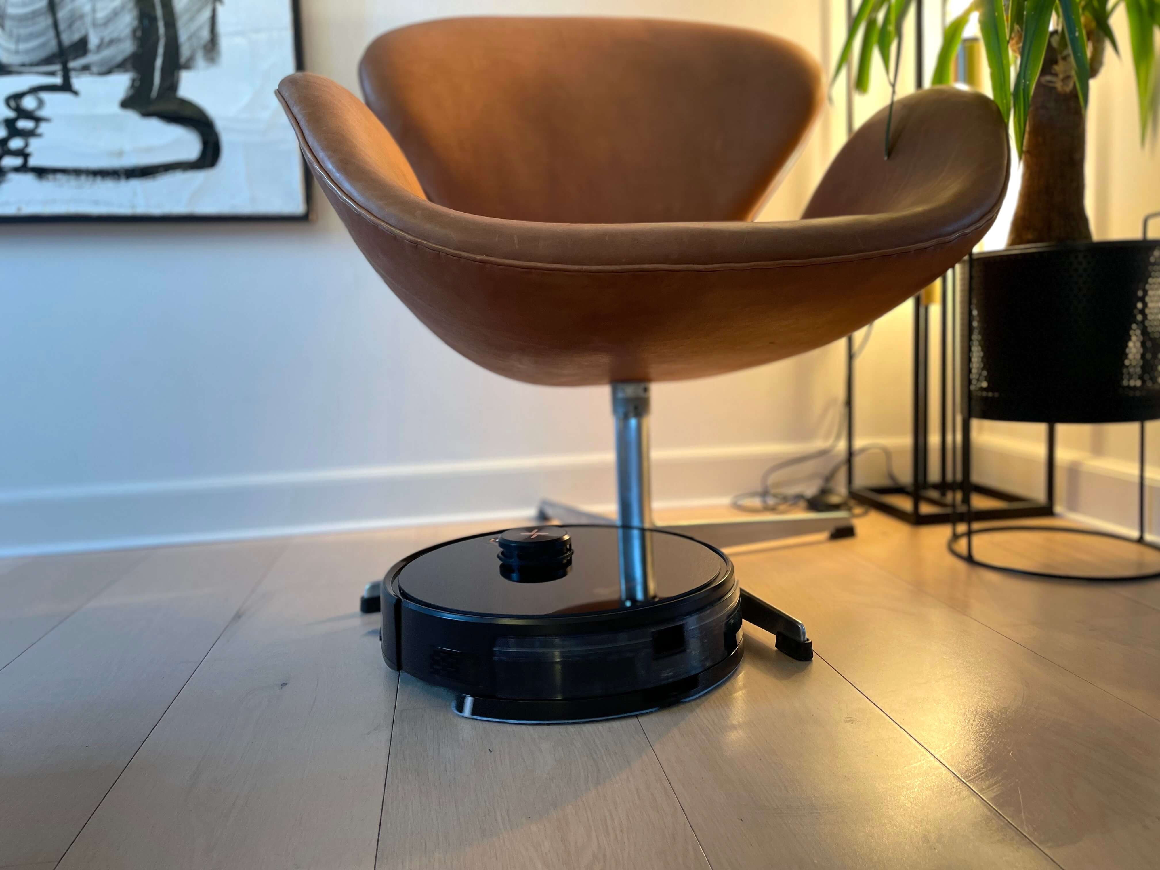 Neatsvor X650 Pro robotstøvsuger ved en stol og plante