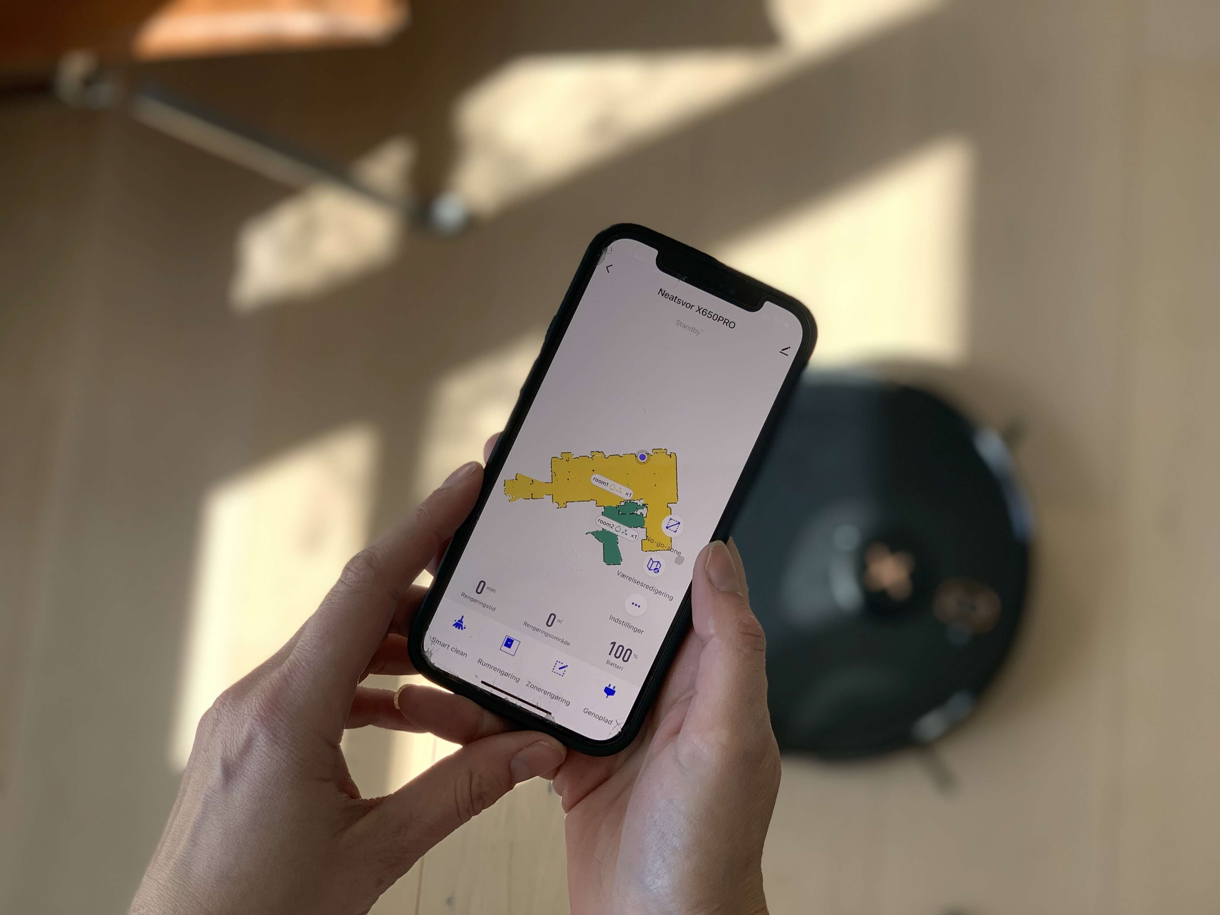 Person med robotstøvsuger APP med optegning af stueetage i hus