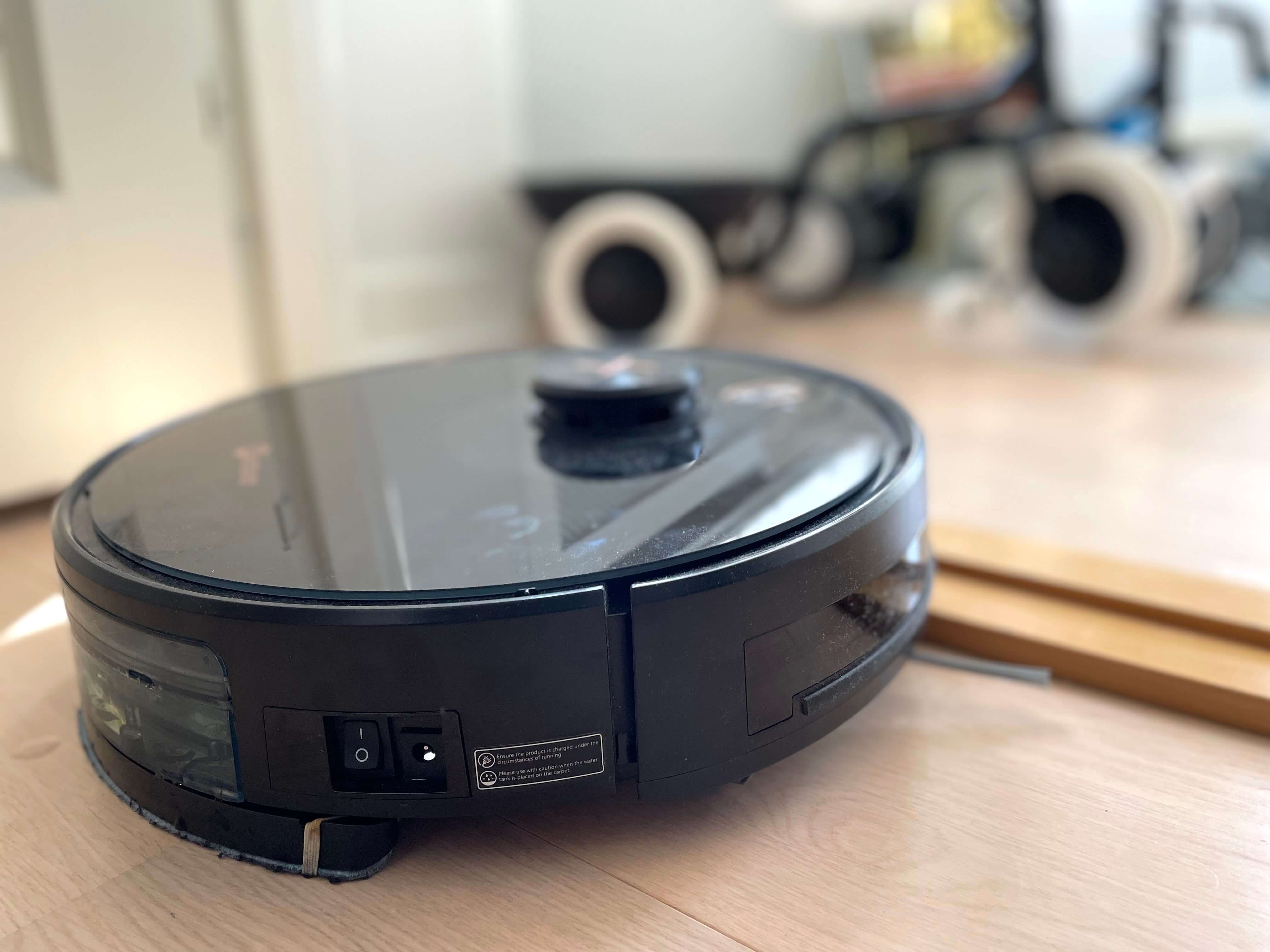Robotstøvsuger kører over dørtrin mellem to rum i hus